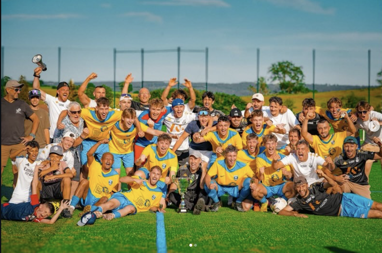 Les joueurs en jaune et les supporters du FCRF célèbrent la victoire en finale autour du trophée